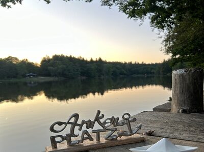Auf einem Holzdock steht ein Schild mit der Aufschrift Anker Platz